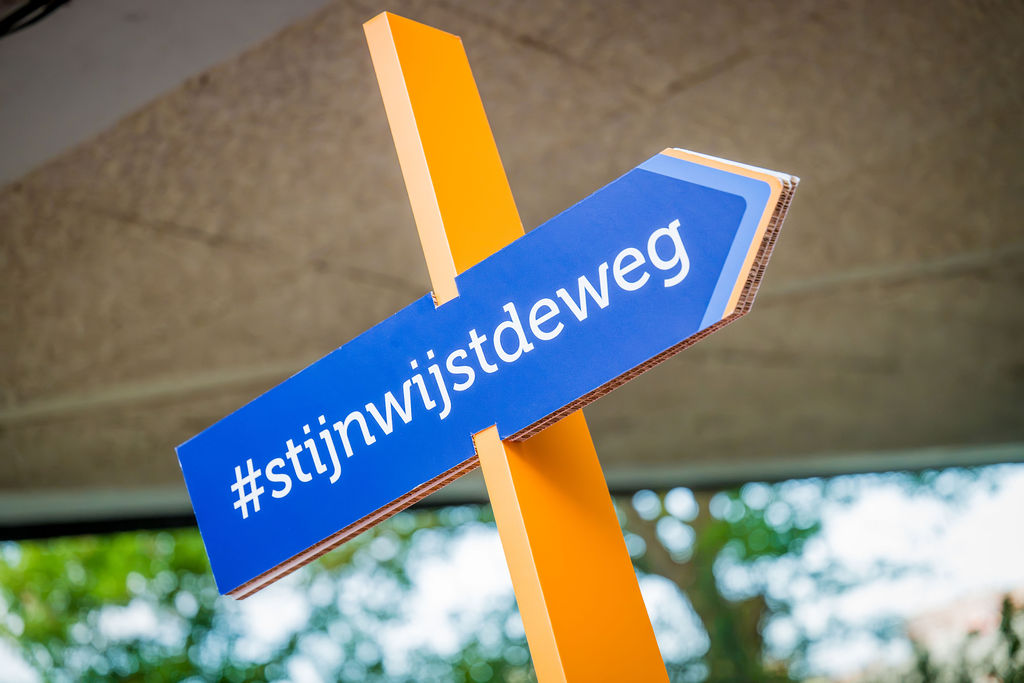 Afbeelding met pijl met daarop de tekst #stijnwijstdeweg